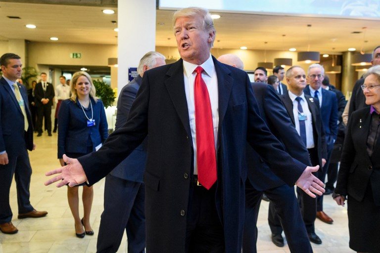Dodging bad headlines and boos, Trump tries to charm Davos