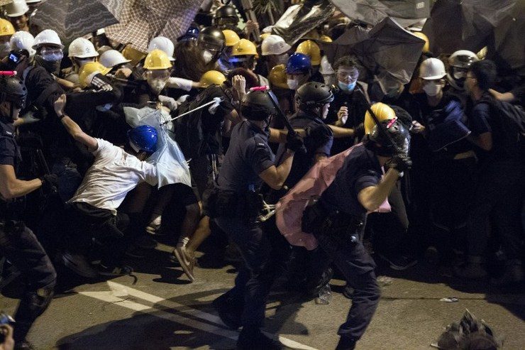 VIOLENCE. Police use batons against pro-democracy protesters near the government headquarters in the Admiralty district of Hong Kong on December 1, 2014. Dale de la Rey/AFP
