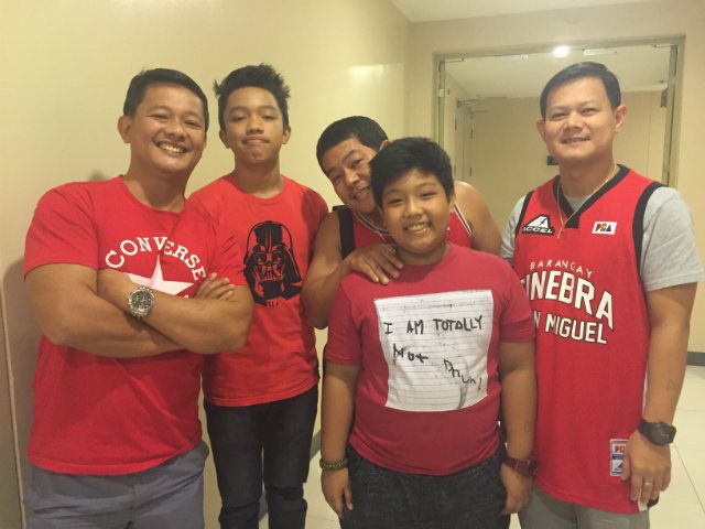 CONFIDENT FANS. Bernard Navarra (L), a SAF trooper, poses for a photo with his family as they wait for Ginebra players to come out of the locker room. Photo by Jane Bracher/Rappler  