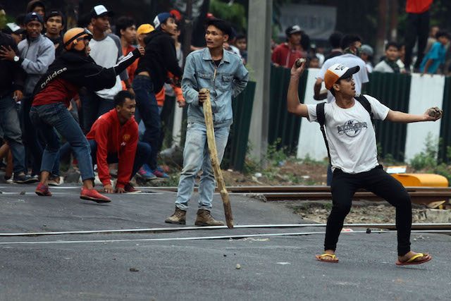 RUSUH JAKMANIA. Pendukung Jakmania melempar batu ke arah polisi yang sedang berjaga di Stadion Gelora Bung Karno, Minggu, 18 Oktober 2015. Foto oleh Rappler 