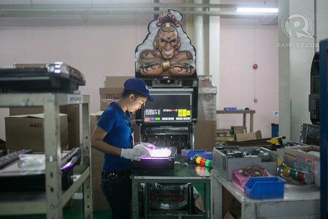 SUPERVISING. A worker calibrates an electronic display under a Genie's gaze. 