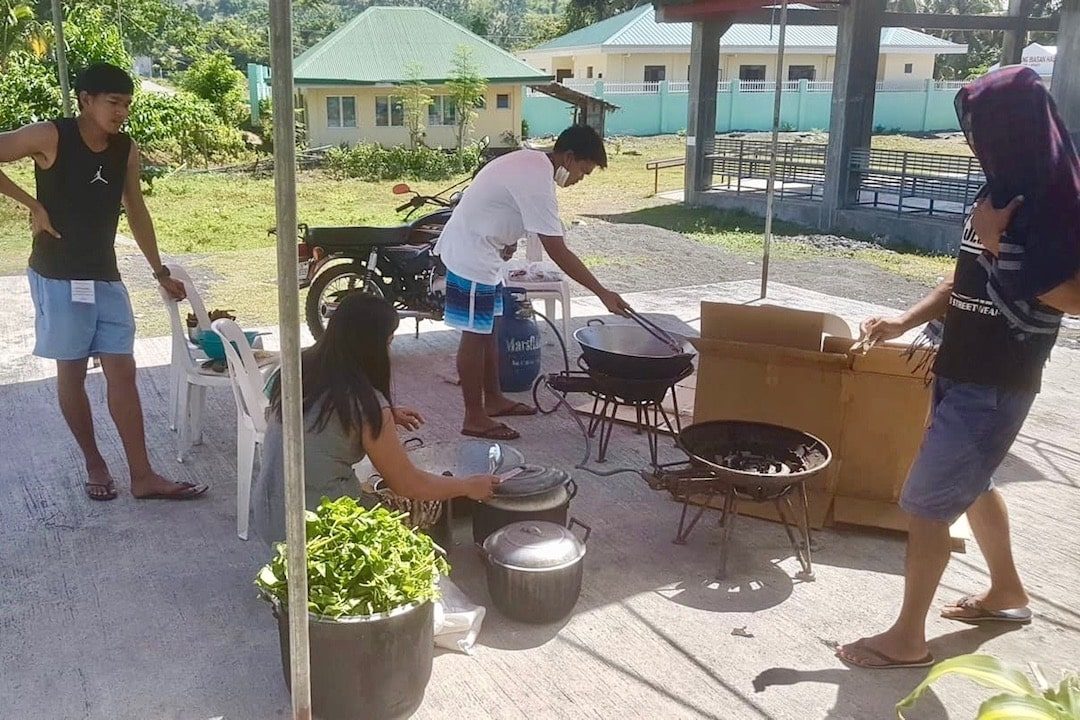 COMMUNITY KITCHEN. Barangay Buluang staffers cook for their constituents. Photo from Alan Bolo 
