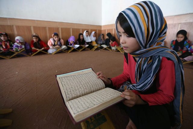Seorang gadis kecil membaca Al-Qur’an di Herat, Afghanistan, 20 Juni 2015. Foto oleh EPA 