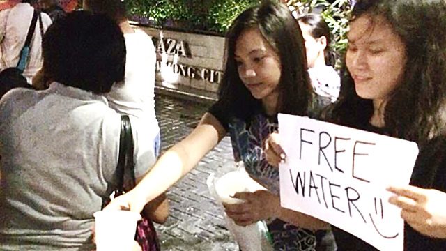 FREE WATER. The photo of Ela and Frances Florendo giving free water to stranded commuter was a bright spot during the Iglesia ni Cristo protests, say netizens. Photo by Alice Sanchez 