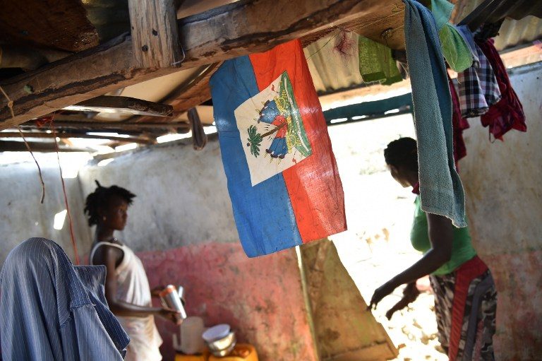 CLEAN-UP. Valencia (L) cleans her house that was damaged in hurricane Matthew, in Jeremie, in western Haiti, on October 7, 2016. Hector Retamal/AFP 