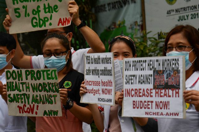PROTECT. Health workers wearing masks carry placards as they hold a protest calling for safety as the country faces a novel coronavirus outbreak. Photo by Ted Aljibe/AFP 