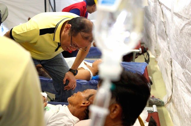 YOLANDA SURVIVOR. President Benigno Aquino III checks on a Yolanda survivor in a mobile hospital on November 18, 2013. Photo by Gil Nartea/Malacañang Photo Bureau   