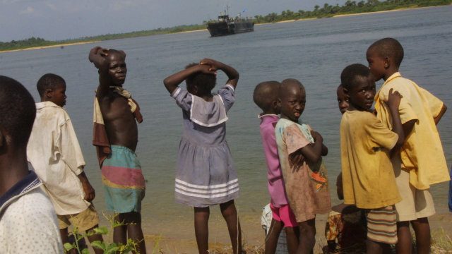 Liberian children await Dutch Gun-boat bringing relief food and aid workers in Robertsport in December of 2003. Photo from EPA