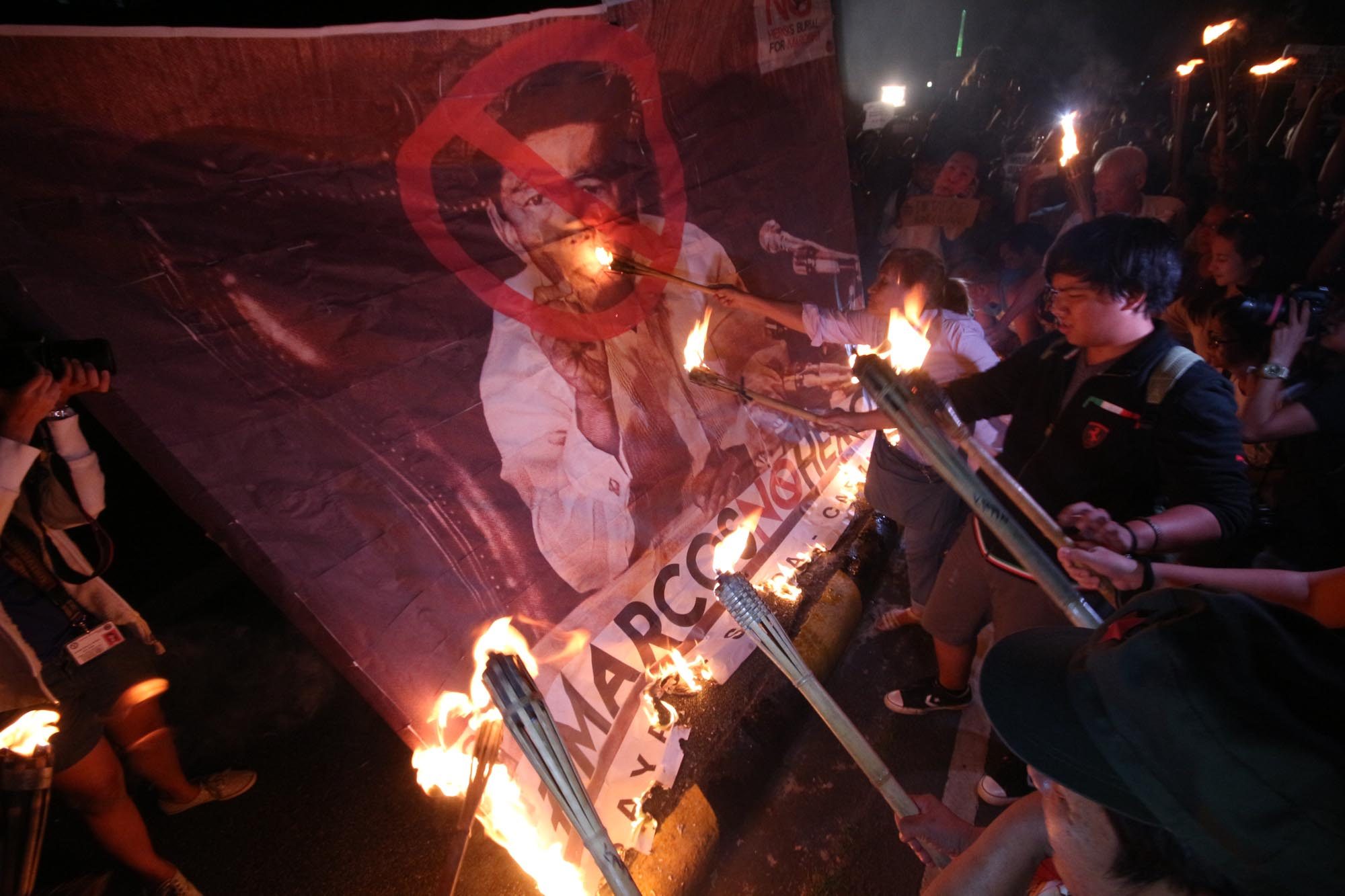NEVER AGAIN. UP students and Martial Law victims torch a large picture of the late dictator Ferdinand Marcos in a protest rally at the UP compound to condemn the Supreme Court's decision granting hero's burial of in the Libingan ng mga Bayani. Photo by Joel Liporada/ Rappler 