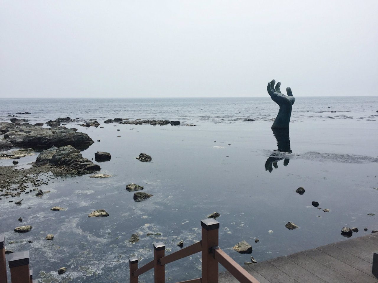 HAND OF SANGSAENG. You can see the famous Hands of Harmony reach for the sky. One is in the ocean, while the other hand is on land. 