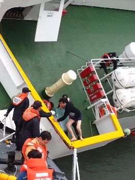 CAPTAIN LEAVES FERRY. The cellphone video footage shows Lee Joon-seok (R), the captain of the Sewol, fleeing from the sinking ferry. Photo by South Korea Coast Guard/EPA