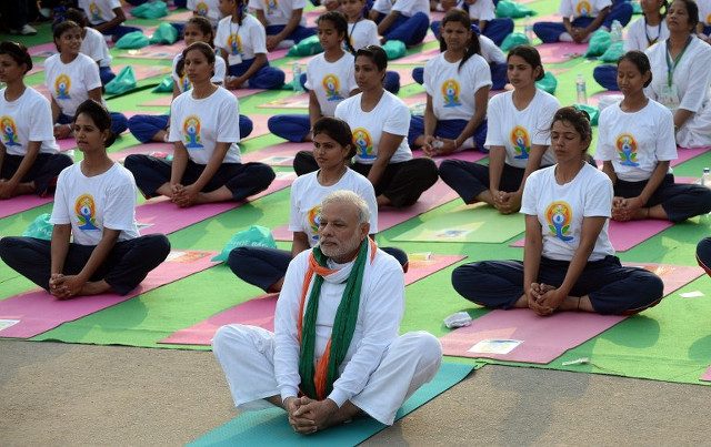 YOGA DAY. Indian Prime Minister Narendra Modi (C) participates in a mass yoga session along with other Indian yoga practitioners to mark the International Yoga Day on Rajpath in New Delhi on June 21, 2015. AFP PHOTO / PRAKASH SINGH 