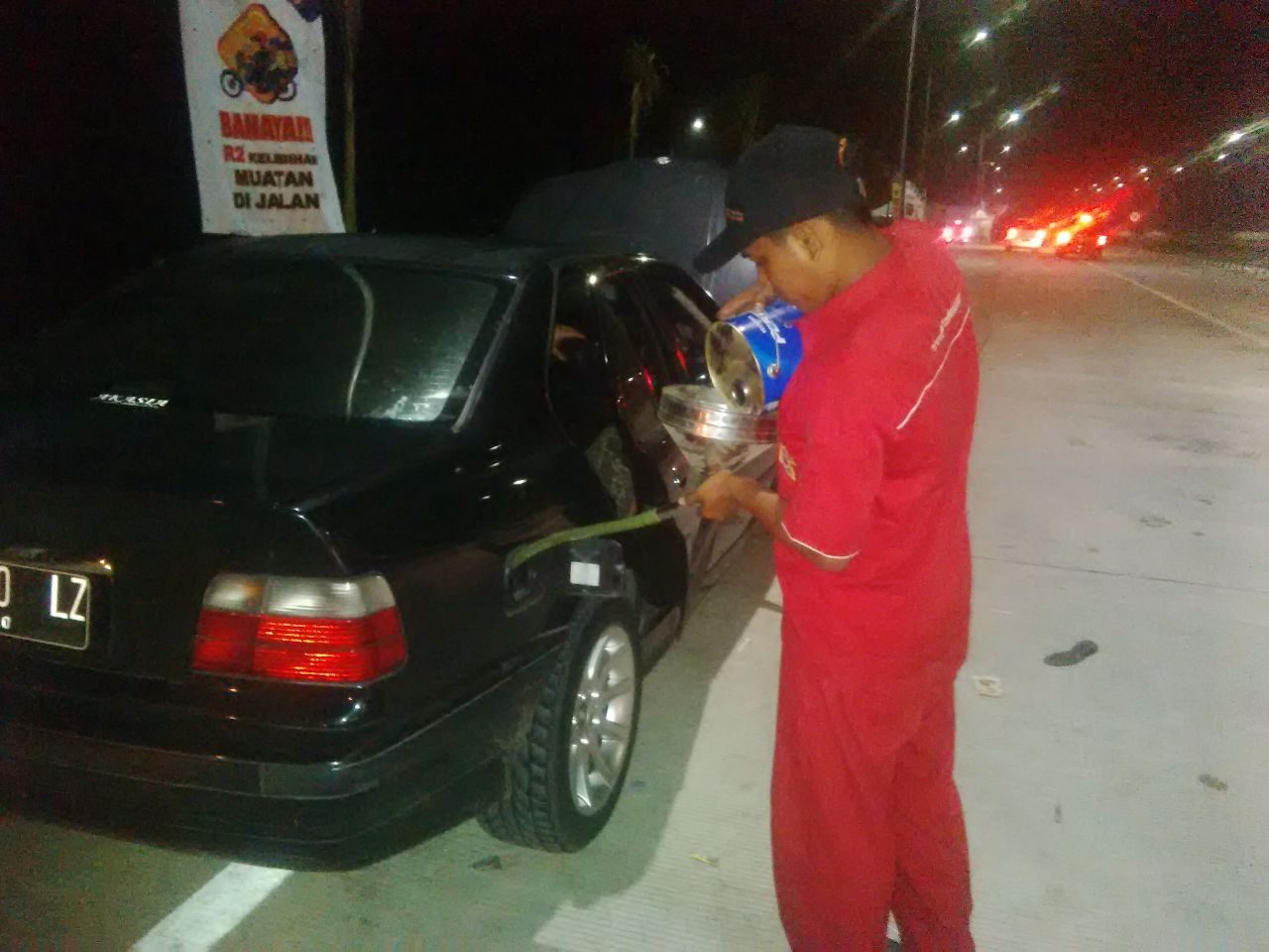 Petugas Pertamina mengisi BBM ke dalam tangki bensin kendaraan pemudik di pinggir jalan tol. Foto dari Pertamina 