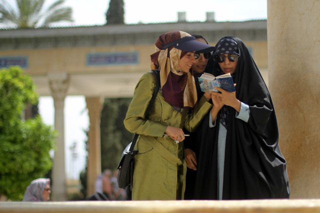 POET OF LOVE. Young women read poetry at the tomb of Hafez in Shiraz. Photo by Patricia Evangelista / Rappler
