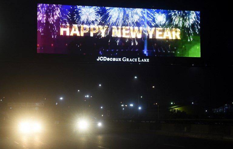 NIGERIA. Motorists drive past an illuminated billboard on a highway just after midnight on New Year's Day in Lagos. Photo by Pius Utomi Ekpei/AFP 