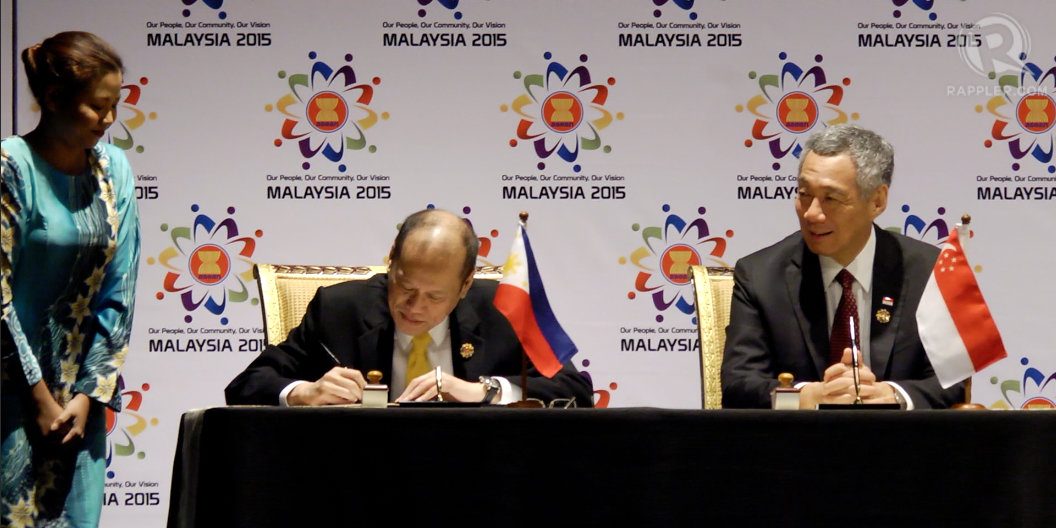 TAKING TURNS. Philippine President Benigno Aquino III signs the ASEAN Declaration on the Establishment of the ASEAN Community. Looking on is Singapore Prime Minister Lee Hsien Loong. 