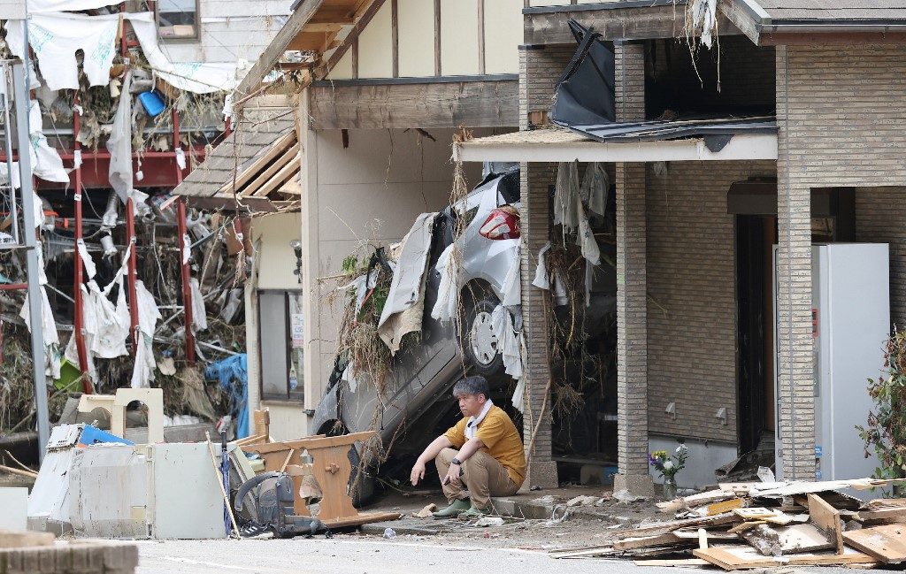 DESTROYED. A man sits outside the house of his aunt, who died from flooding of the Kuma river due to torrential rains, in Yatsushiro, Kumamoto Prefecture on July 8, 2020. Photo by STR/JIJI PRESS/AFP 