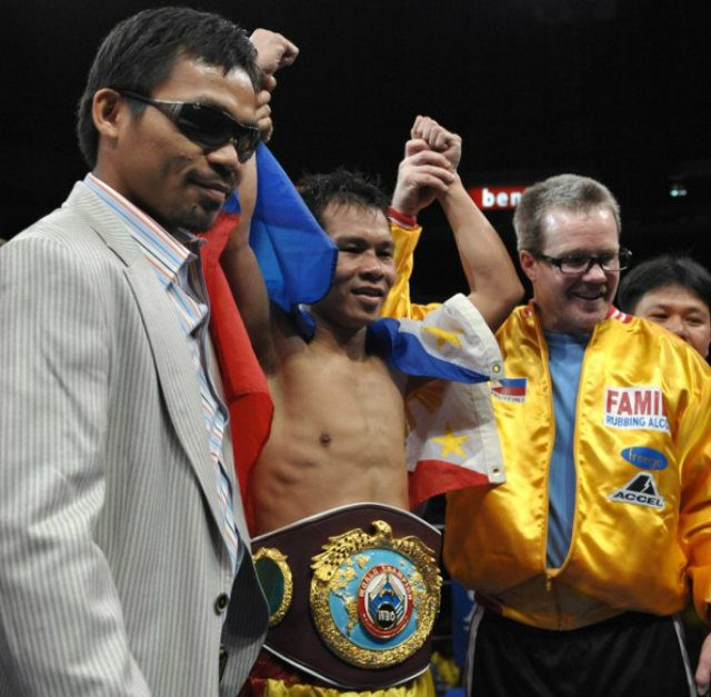 Gerry Penalosa (C) stands between Pacquiao (L) and trainer Freddie Roach (R) after defending his title against Ratanachai Sor Vorapin by eighth round knockout in 2008. Photo by Jay Directo/AFP
 