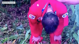 Seorang pilot pesawat akrobatik tim Jupiter Indonesia terlihat menekuk badannya, ia diduga masih syok karena pesawatnya terbakar dan jatuh di Bandara Langkawi, Malaysia, Minggu, 15 Maret 2015. Foto screen shoot dari Youtube.  