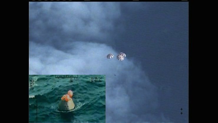 SPLASHDOWN. NASA's Orion spacecraft is seen from an unpiloted aircraft descending under three massive red and white main parachutes and then shortly after its bullseye splashdown in the Pacific Ocean, 600 miles southwest of San Diego, California. Image courtesy NASA