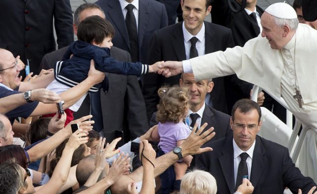 HANDSHAKE. Pope Francis reaches out to shake the hand of a young child on his arrival in St. Peter's Square on October 15, 2014 for the weekly Wednesday General Audience. Photo by Claudio Peri/EPA