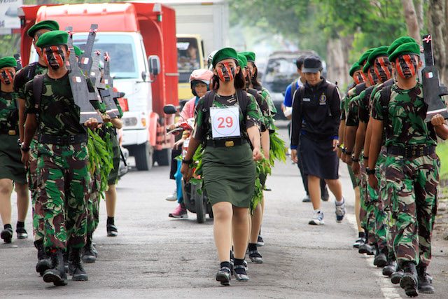 GERAK JALAN BELA NEGARA. Sekelompok peserta gerak jalan sehat dengan kostum ala militer melintas di jalan raya Tulungagung, Jawa Timur, pada 16 Desember 2015. Foto oleh Destyan Sujarwoko/Antara  