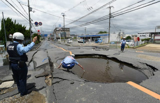 OSAKA EARTHQUAKE. Police check a collapsed road following an earthquake in Takatsuki, north of Osaka prefecture on June 18, 2018. Stringer photo/Jiji Press/AFP   