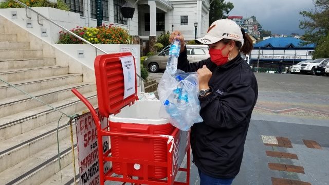HONESTY CART. Janeth Martin, business developer at Coca-Cola Baguio Sales Office, adds new Wilkins stocks into an Honesty Cart. 