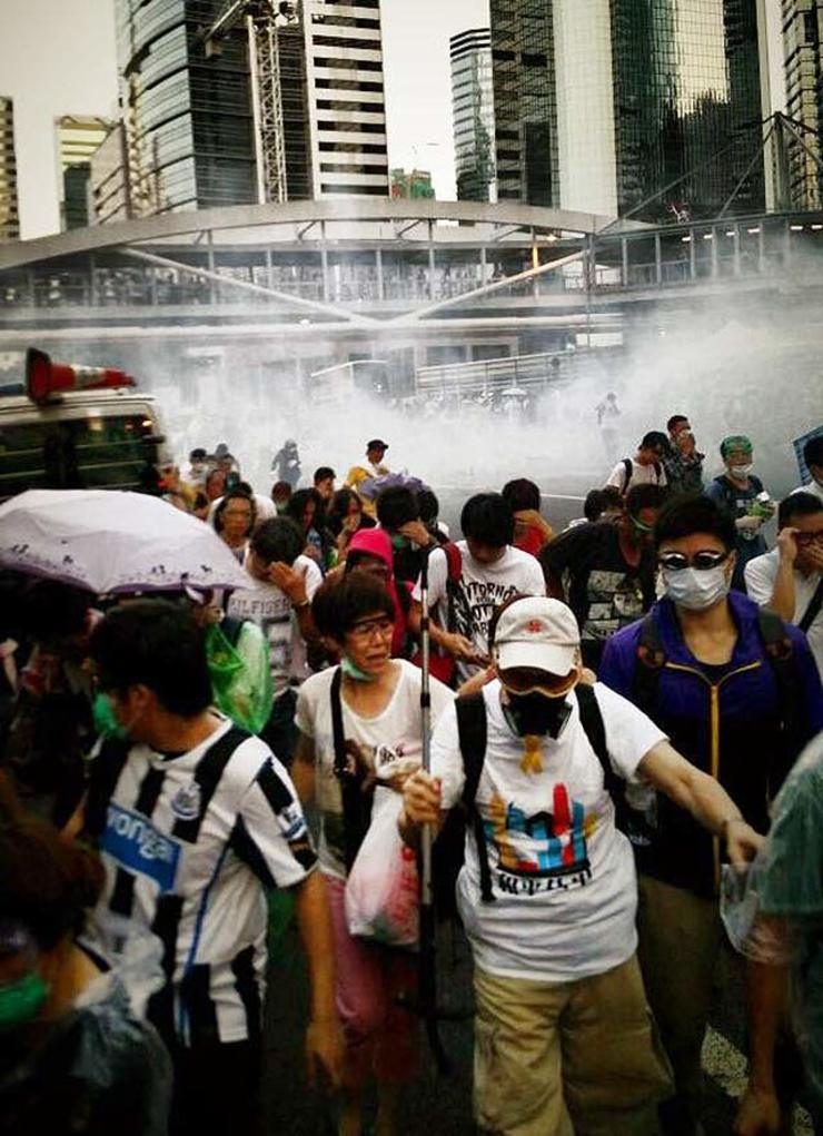 TEAR GAS CLOUD. Protestors wear face masks to protect themselves from tear gas. Photo by Jason Y Ng