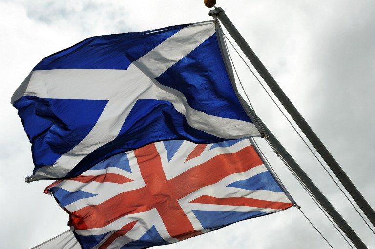 UNION IN PERIL? The Saltire, the flag of Scotland, flies beside the Union flag at the site of the Auld Acquaintance cairn, on the banks of the River Sark in Gretna in Scotland, on August 17, 2014. Andy Buchanan/AFP
