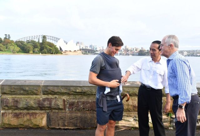 DISAPA WARGA. Presiden Joko "Jokowi" Widodo dan Perdana Menteri Malcolm Turnbull disapa oleh warga Australia yang tengah menggendong puterinya di Royal Botanic Garden. Foto diambil dari akun Twitter @KSPgoid 