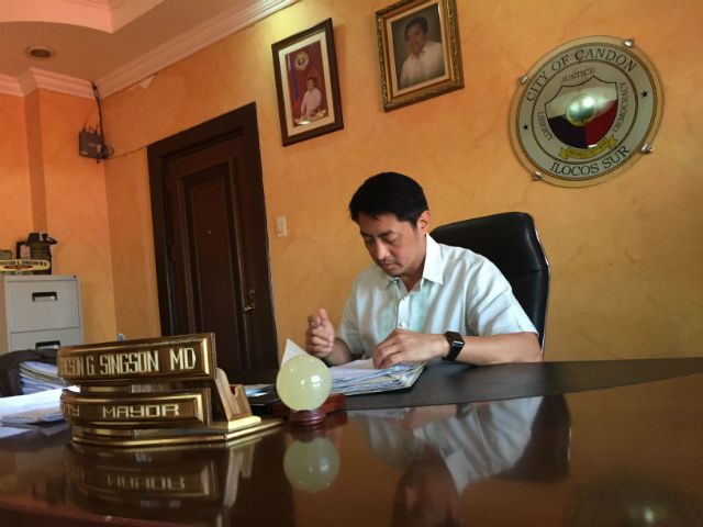 AT WORK. Singson signs papers inside his office at the Candon City Hall.  