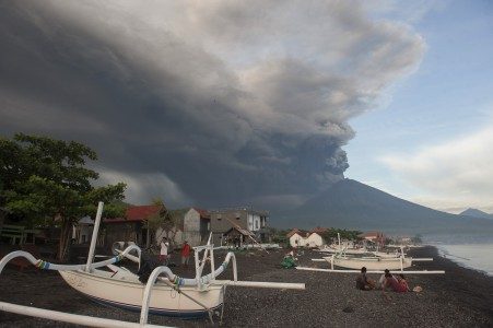 Sejumlah warga menikmati liburan dengan latar belakang Gunung Agung meletus, di Pantai Jemeluk, Karangasem, Bali, Minggu (26/11). FOTO oleh ANTARA/Nyoman Budhiana 