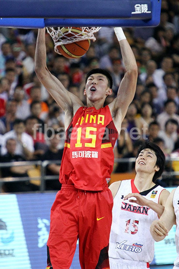 China's Zhou Qi throws down a two-handed jam against Japan. Photo from fibasia.net