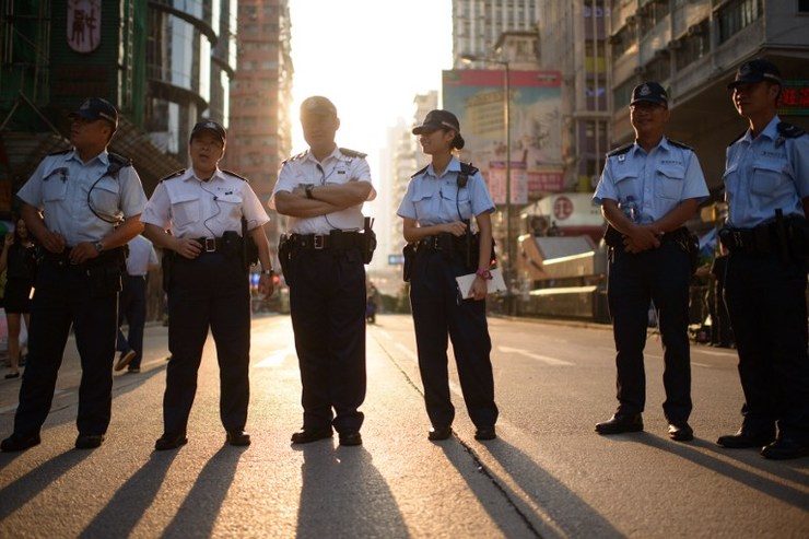 Police stand on a road occupied by pro-democracy protesters in the Mong Kok district of Hong Kong on October 12, 2014. Ed Jones/AFP