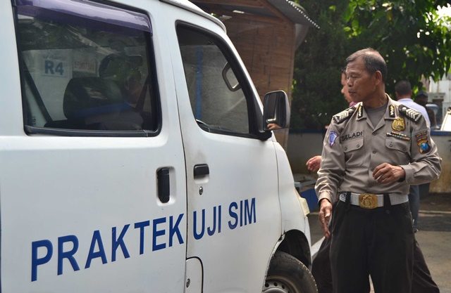 PRAKTEK BERLISENSI.  Bripka Seladi membantu warga bernama Nur Sulistiono untuk mengikuti tes SIM pada Jumat, 20 Mei.  Foto oleh Dyah Pitaloka/Rappler 