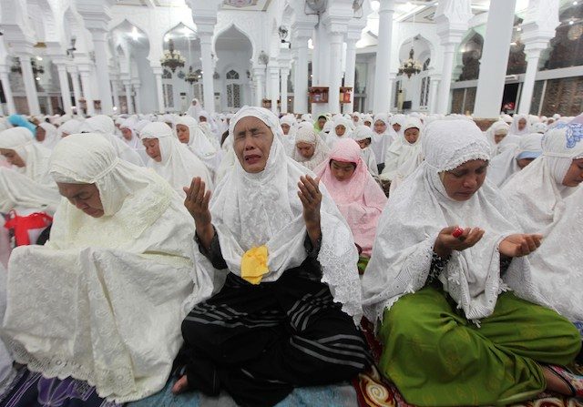 PRAYERS FOR THE VICTIMS. Acehnese residents react during a mass prayer at the Baiturrahman mosque in Banda Aceh, Indonesia, 25 December 2014. Adi Weda/EPA
