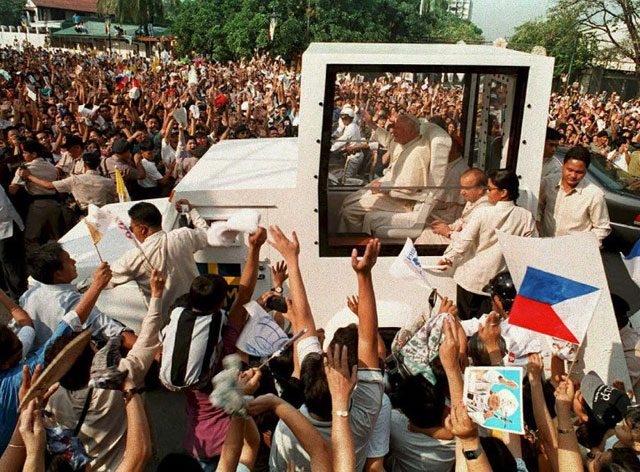 Pope John Paul II – and his security team –wade through the crowd during his 1995 visit to the Philippines. AFP file photo