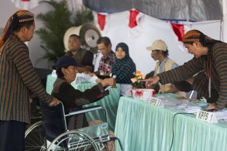 Warga lanjut usia menggunakan hak pilihnya dengan dibantu petugas KPPS dalam Pilkada DKI Jakarta di TPS 04 Gambir, Jakarta (15/2). Foto oleh Rosa Panggabean/ANTARA 