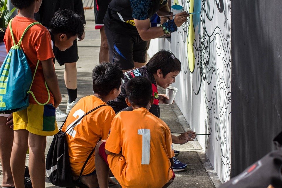 WATCH AND LEARN. A group of young boys pay close attention to Nini Sacro while she paints the outlines. Photo courtesy of Paul Basco.  