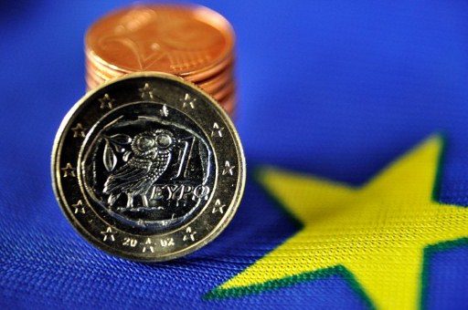 IN OR OUT OF EURO? 1 euro coin made in Greece and a pile of eurocents displayed on the European flag. Photo by AFP