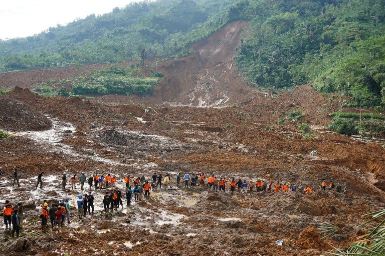 A rescue team remove victims bodies of a landslide triggered by torrential downpours at Jemblung village in Banjarnegara, Central Java province on December 13, 2014. Photo by AFP