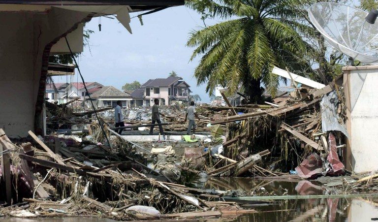 Survivors walk through the devastation in the capital Banda Aceh.

