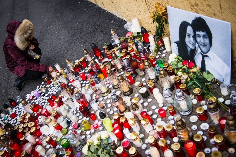 REMEMBERED. A woman places a candle in front of a portrait of Slovak investigative journalist Jan Kuciak and his girlfriend Martina Kusnirova in the center of Bratislava on February 27, 2018. File Photo by Vladimir Simiceck/AFP   