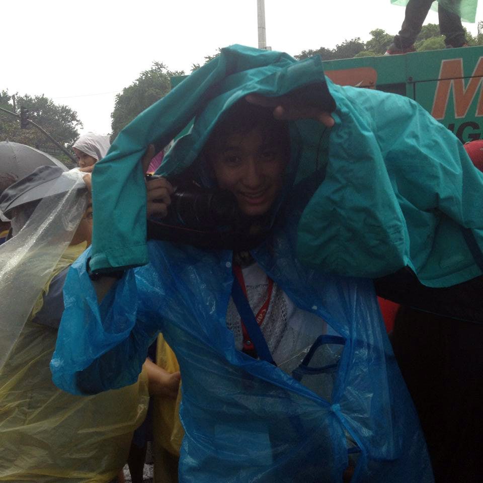 SOAKED. Wearing a raincoat, Mover Nick Tan takes photos of devotees who flocked to Manila for the last events of the papal visit. Photo by Raisa Serafica