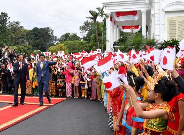 DISAMBUT. Perdana Menteri Shinzo Abe disambut oleh ratusan siswa SD yang melambai-lambaikan bendera Indonesia dan Jepang di depan Istana Bogor pada Minggu, 15 Januari. Foto diambil dari akun Twitter @KBRITokyo 
