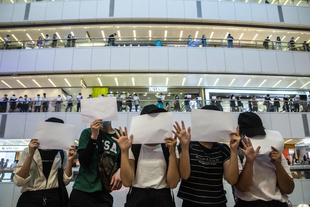 WHITE BUT NOT BLANK. Protesters hold up blank papers during a demonstration in a mall in Hong Kong on July 6, 2020. Photo by Isaac Lawrence/AFP  