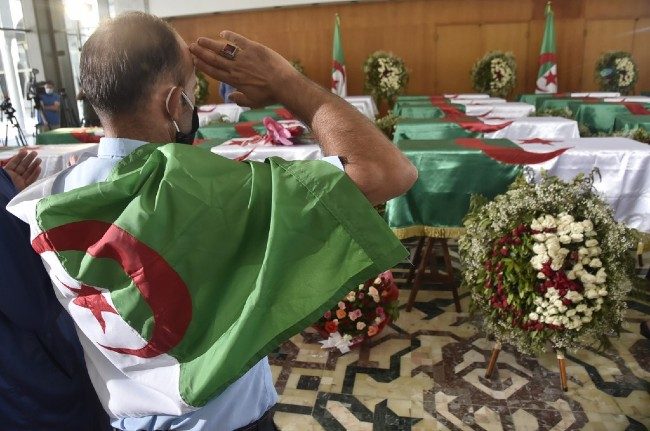 FINAL RITES. An Algerian man pays respect in front of the national flag-draped coffins containing the remains of 24 Algerian resistance fighters decapitated during the French colonial conquest of the North African country, presented at the capital's Palais De La Culture Moufdi Zakaria. Photo by Ryad Kramdi/AFP 