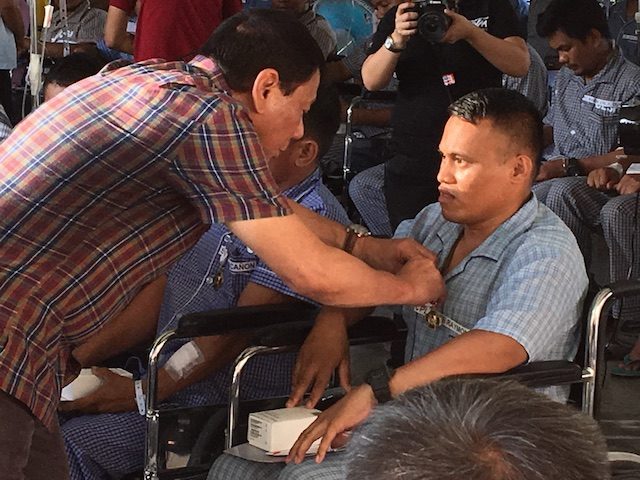 HONORED. President Rodrigo Duterte pins the Wounded Personnel Medal on 81 soldiers who fought in Marawi City. 