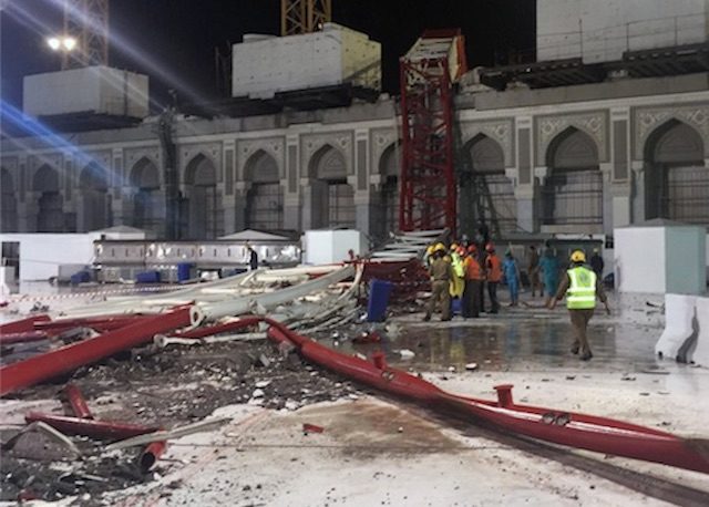 MUSIBAH CRANE. Tim gawat darurat Saudi berdiri di dekat crane yang jatuh menimpa Masjidil Haram. Foto oleh AFP. 